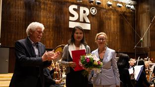 Yang Song in der Mitte – links: Sylvain Teutsch, Institut Théodore Gouvy; rechts: Maria Grätzel, DRP-Orchestermanagerin (Foto: Astrid Karger)